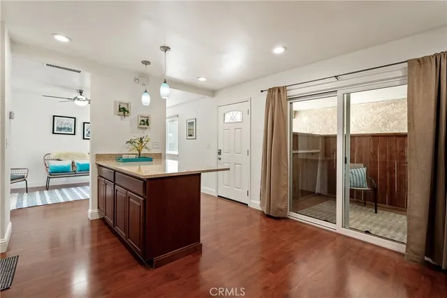a kitchen with kitchen island wooden floor center island and stainless steel appliances