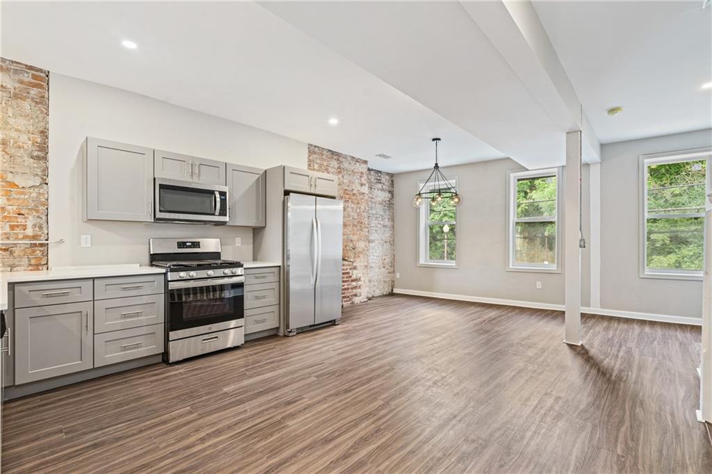 1127 Troy Hill Road Pittsburgh, PA 15212 - Photo 13 of 25 a kitchen with granite countertop a refrigerator and a stove top oven