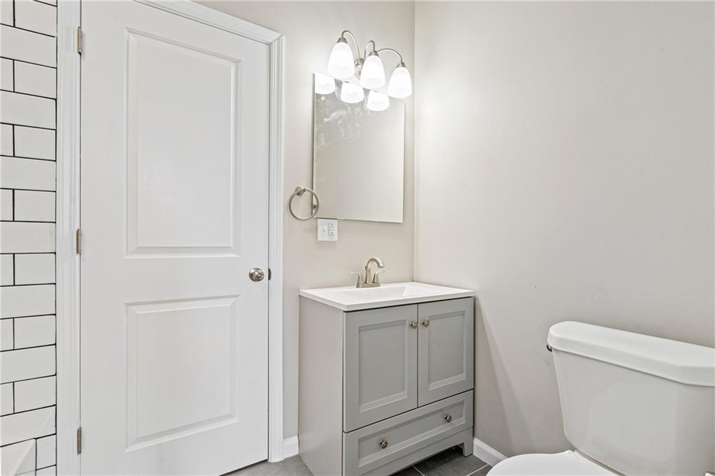 1127 Troy Hill Road Pittsburgh, PA 15212 - Photo 19 of 25 a bathroom with a toilet a sink a mirror and vanity