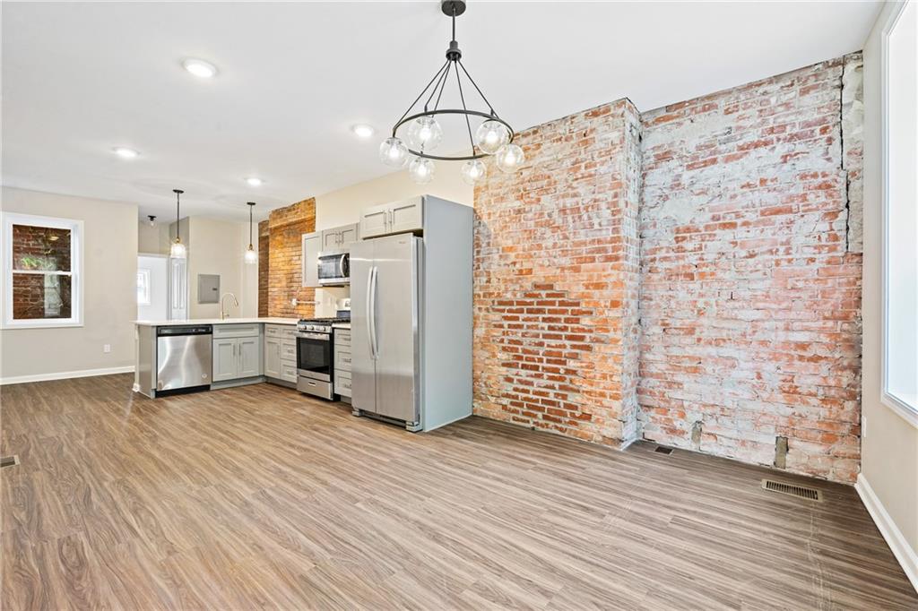 1127 Troy Hill Road Pittsburgh, PA 15212 - Photo 2 of 25 a view of a kitchen with wooden floor and an empty room