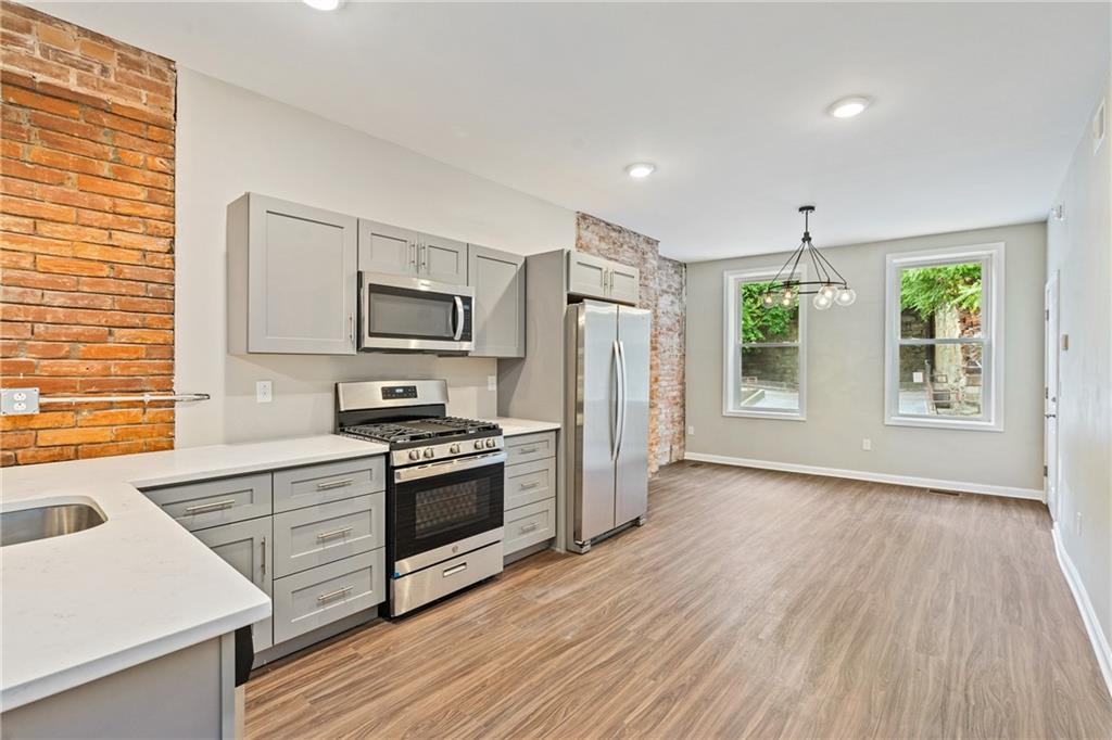 1127 Troy Hill Road Pittsburgh, PA 15212 - Photo 4 of 25 a kitchen with stainless steel appliances a stove top oven a sink and a refrigerator
