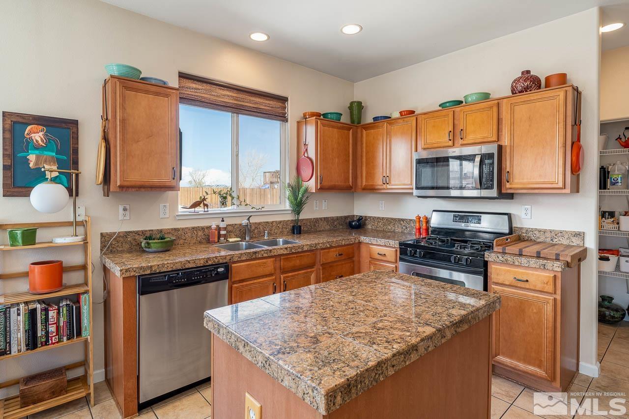 2241 Big Trail Circle Reno, NV 89521 - Photo 19 of 40 a kitchen with stainless steel appliances granite countertop a stove top oven a sink dishwasher and a microwave oven with white cabinets