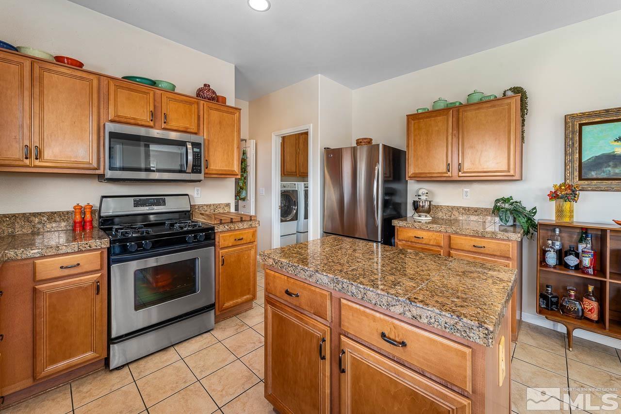 2241 Big Trail Circle Reno, NV 89521 - Photo 20 of 40 a kitchen with stainless steel appliances granite countertop a stove microwave and refrigerator