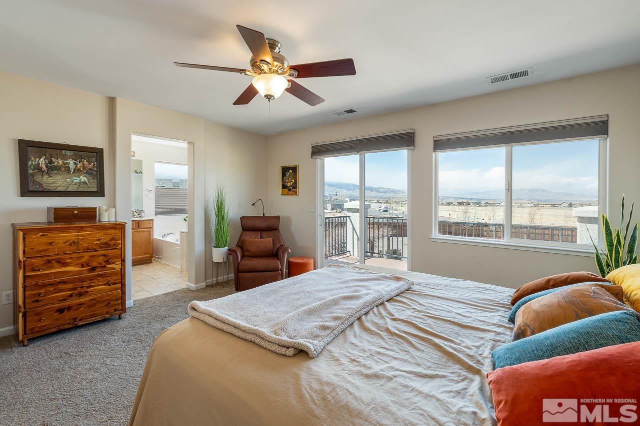 2241 Big Trail Circle Reno, NV 89521 - Photo 8 of 40 a spacious bedroom with a bed a dresser and a large window