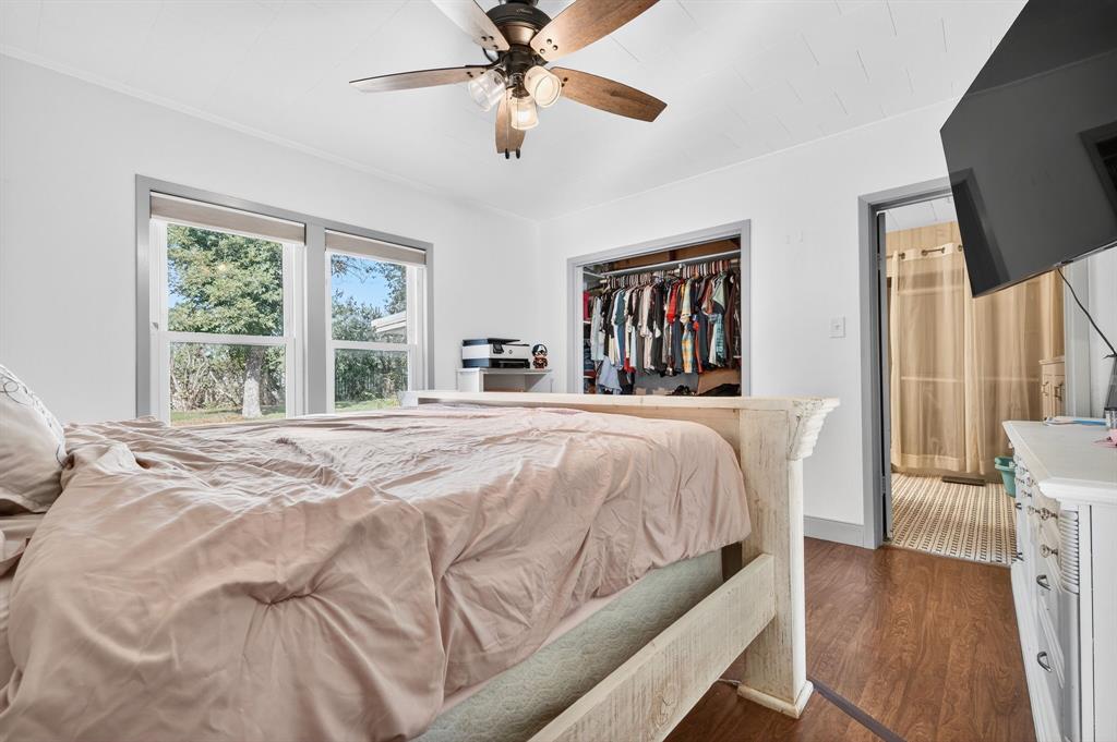 605 Highway 36 Comanche, TX 76442 - Photo 14 of 36 a bedroom with a large bed and a chandelier