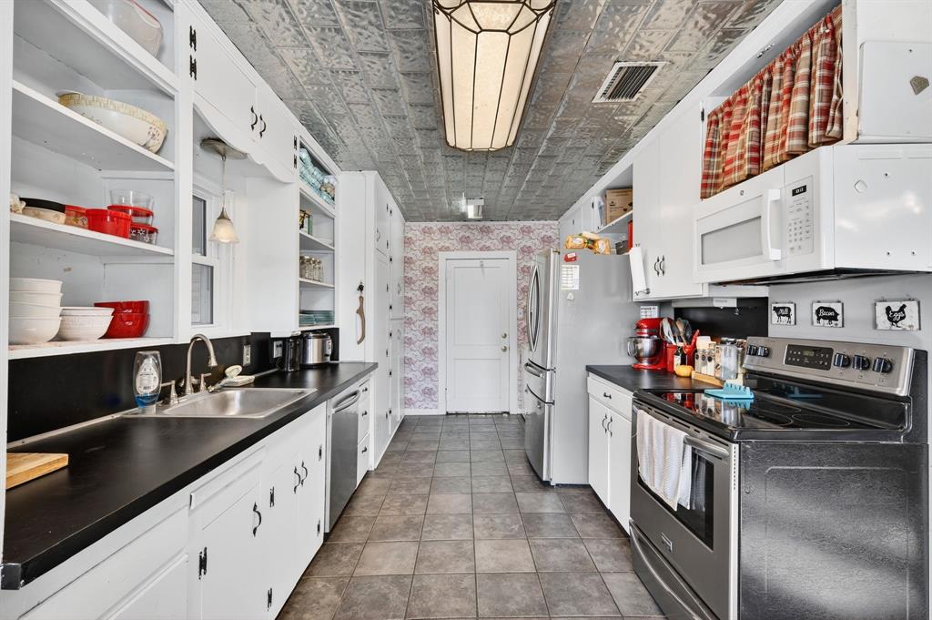 605 Highway 36 Comanche, TX 76442 - Photo 22 of 36 a kitchen with stainless steel appliances granite countertop a sink stove and refrigerator