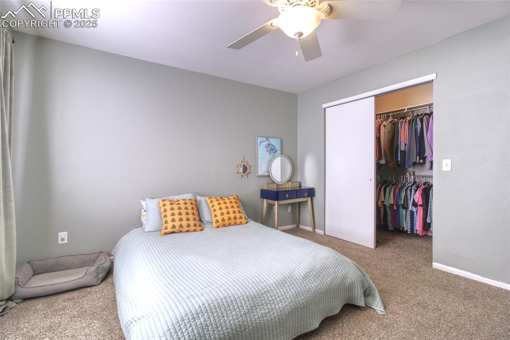 7215 Canal Point Colorado Springs, CO 80922 - Photo 14 of 24 a bedroom with a bed and a chandelier