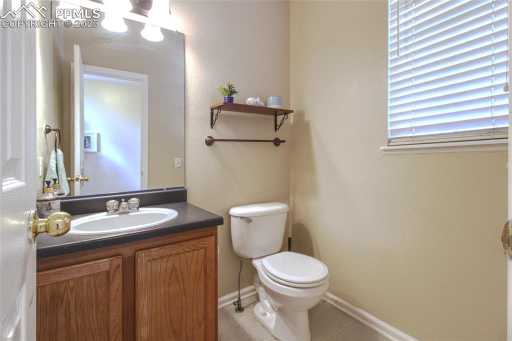 7215 Canal Point Colorado Springs, CO 80922 - Photo 6 of 24 a bathroom with a granite countertop toilet sink and mirror