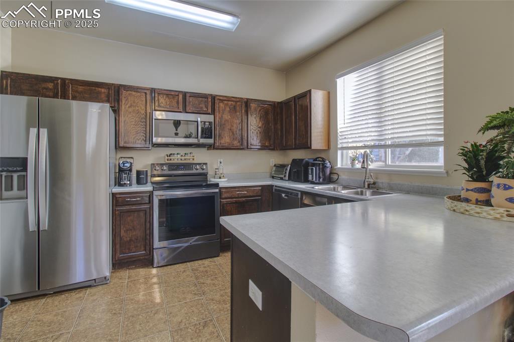 7215 Canal Point Colorado Springs, CO 80922 - Photo 7 of 24 a kitchen with a refrigerator a sink a stove a microwave and island