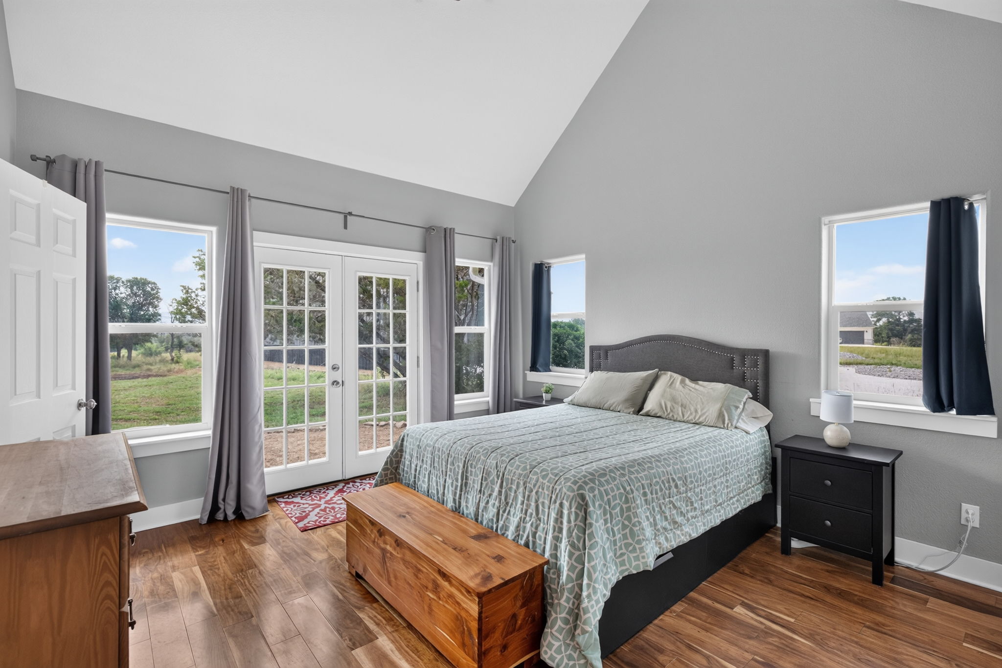 207 Deer Ridge Drive Burnet, TX 78611 - Photo 23 of 36 Natural light pours into this primary bedroom through abundant windows and French doors.