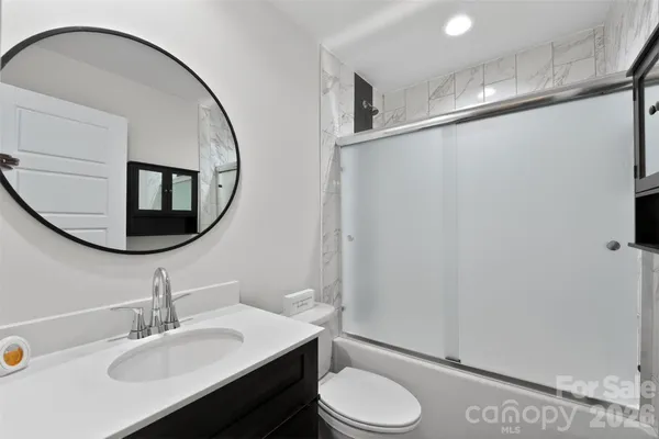 a bathroom with a sink mirror vanity and toilet