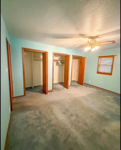 an empty room with windows and closet