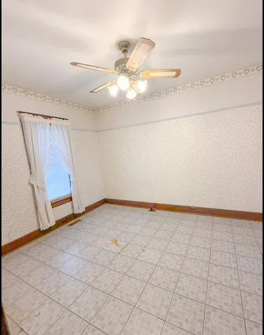 a view of a livingroom with a chandelier fan and window