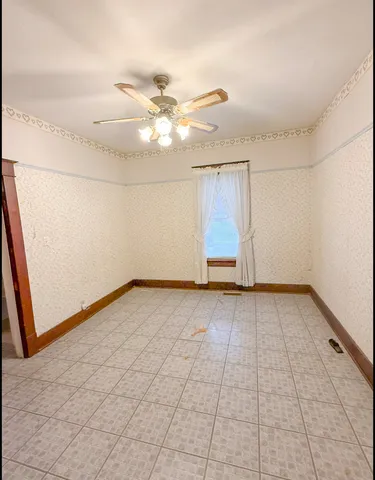 en empty room with windows and fan