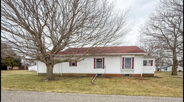 a front view of a house with a yard covered with snow