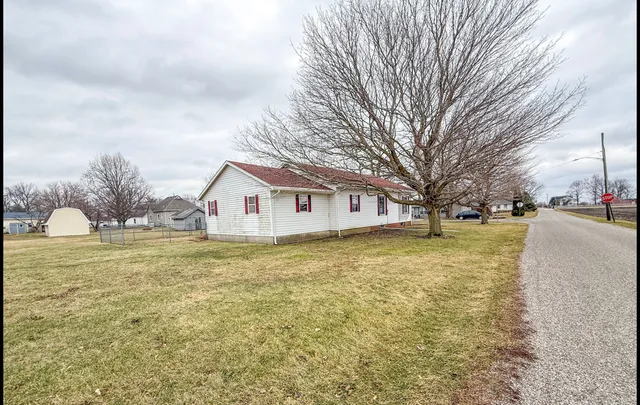 a front view of house with yard and trees around