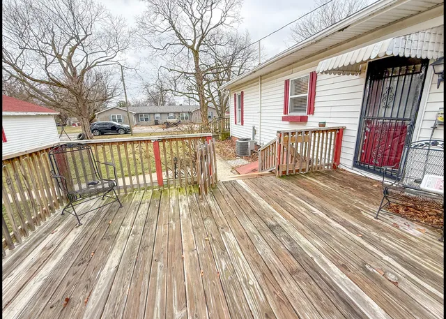 a view of balcony with wooden floor and fence and a floor to ceiling window