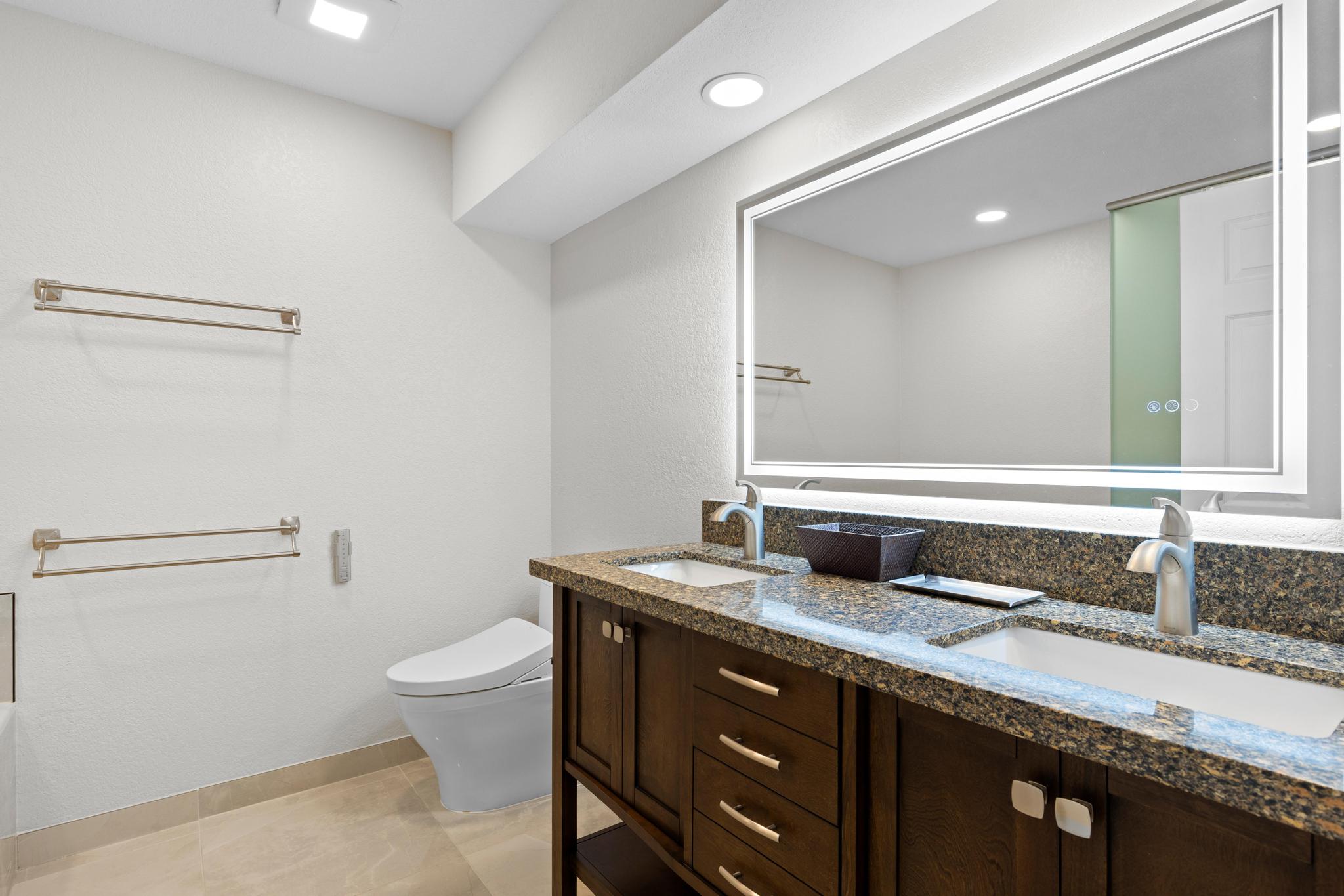 69-450 Bay Club, Unit 236 Waikoloa, HI 96738 - Photo 17 of 22 a bathroom with a granite countertop sink a toilet and a mirror