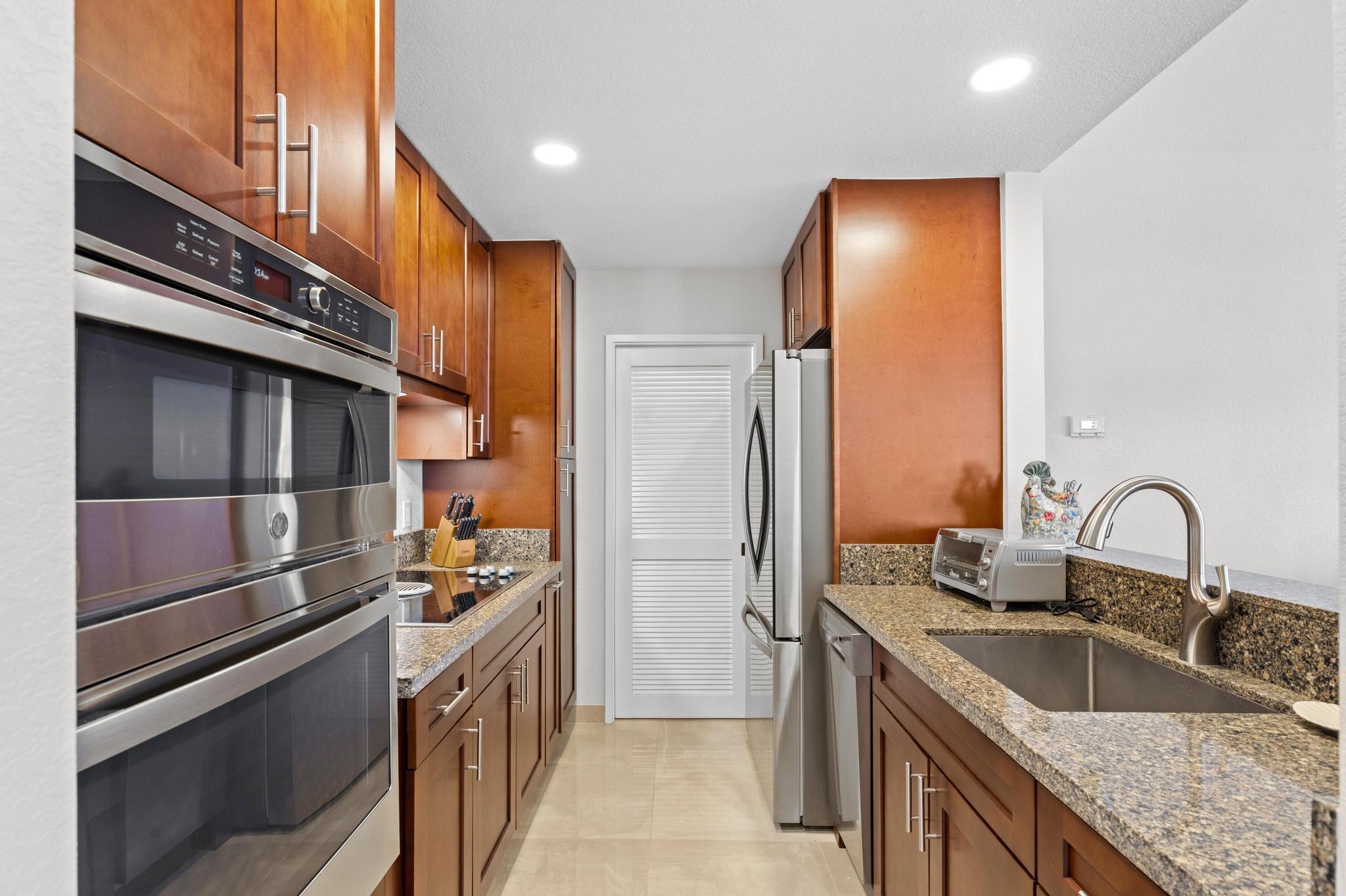 69-450 Bay Club, Unit 236 Waikoloa, HI 96738 - Photo 8 of 22 a kitchen with stainless steel appliances granite countertop a sink and a refrigerator