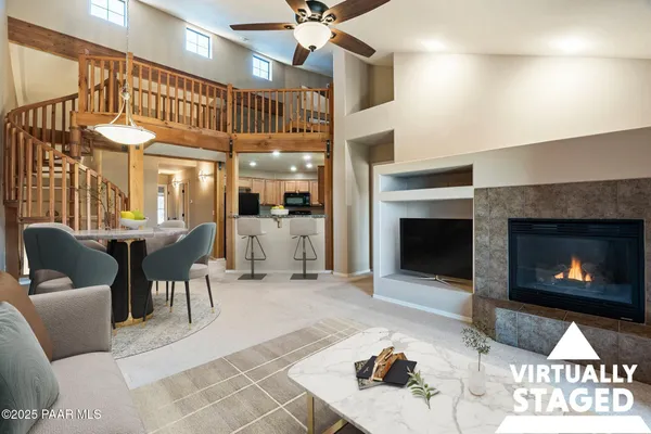 a living room with furniture a fireplace and a chandelier