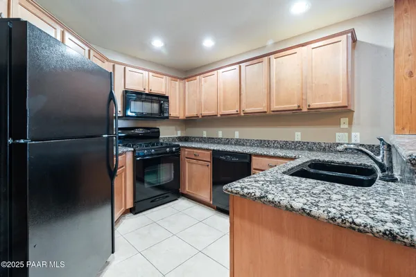 a kitchen with stainless steel appliances granite countertop a refrigerator and a sink