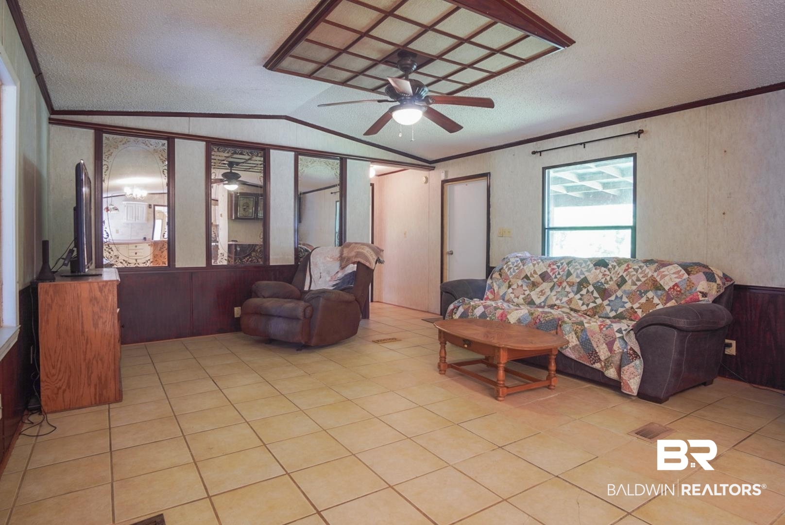 9190 County Road 97 Elberta, AL 36530 - Photo 24 of 53 Living room with crown molding, a textured ceiling, lofted ceiling, light tile patterned flooring, and ceiling fan