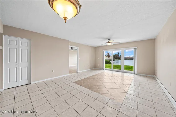 a view of an empty room with a window and chandelier