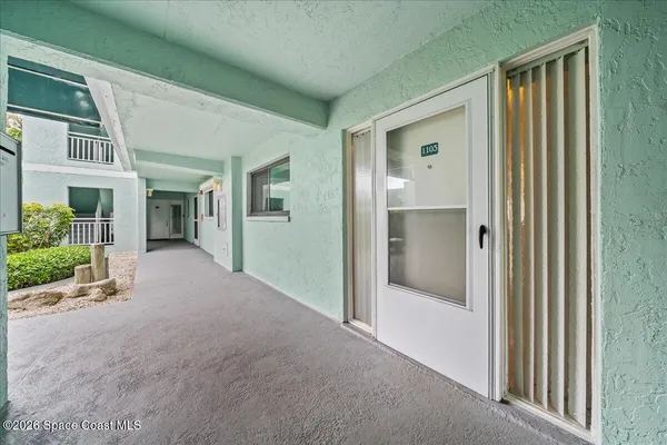 a view of a big room with wooden floor and windows