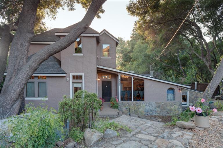 a view of a house with a yard and large tree
