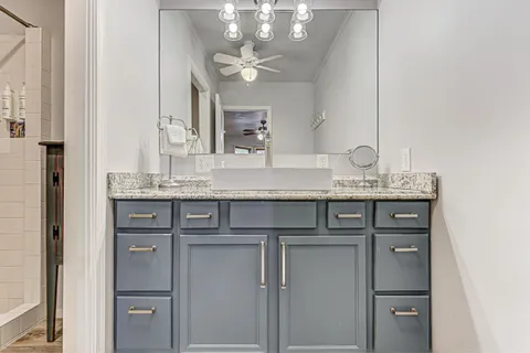 a backyard of a house with a large tree and outdoor seating