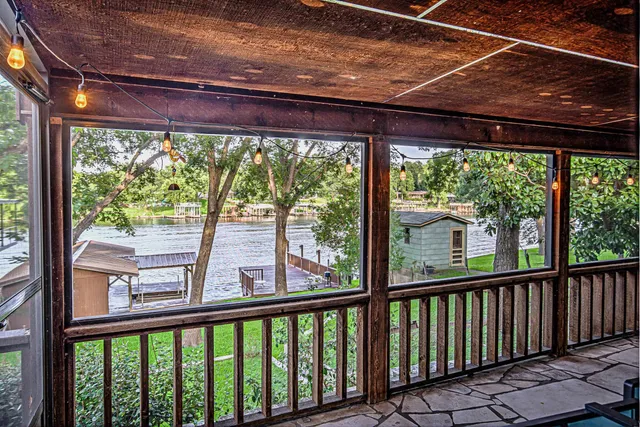 a view of a deck and a backyard with a large tree