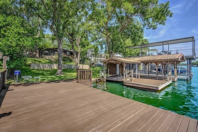 a view of a house with a backyard and a large tree