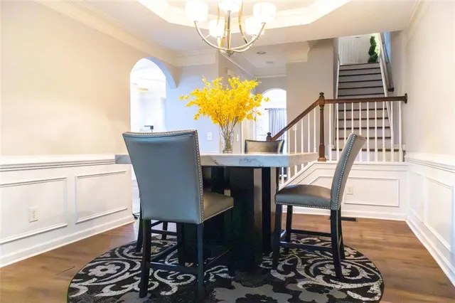 a view of a dining room with furniture a chandelier and wooden floor