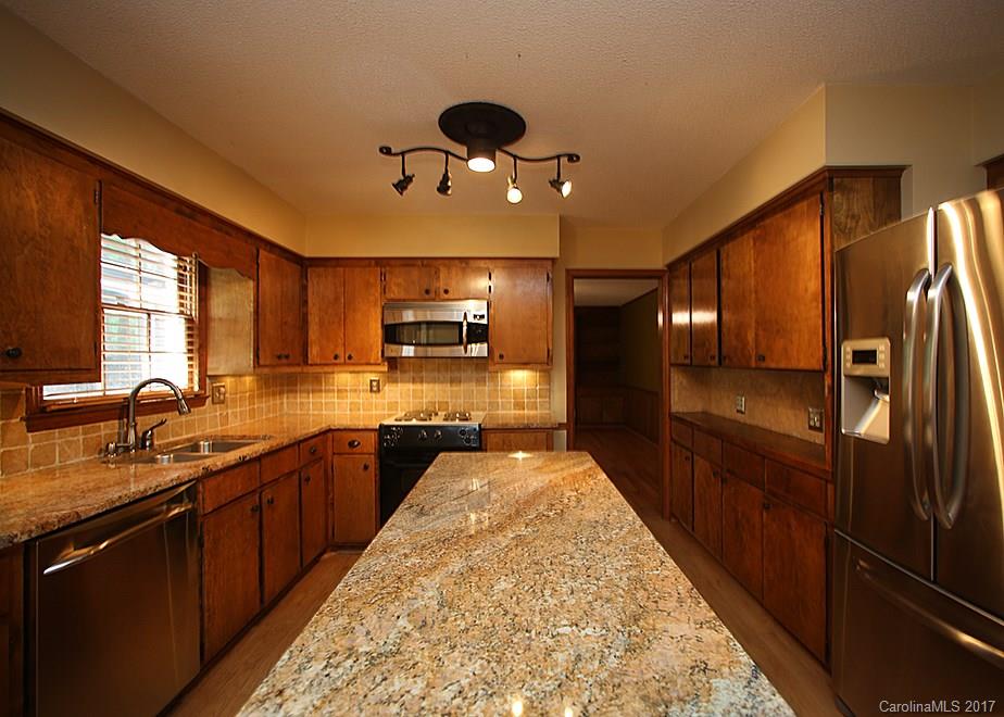 124 Friendfield Drive, Unit 10 Fort Mill, SC 29715 - Photo 8 of 24 a large kitchen with kitchen island granite countertop a sink counter space and stainless steel appliances