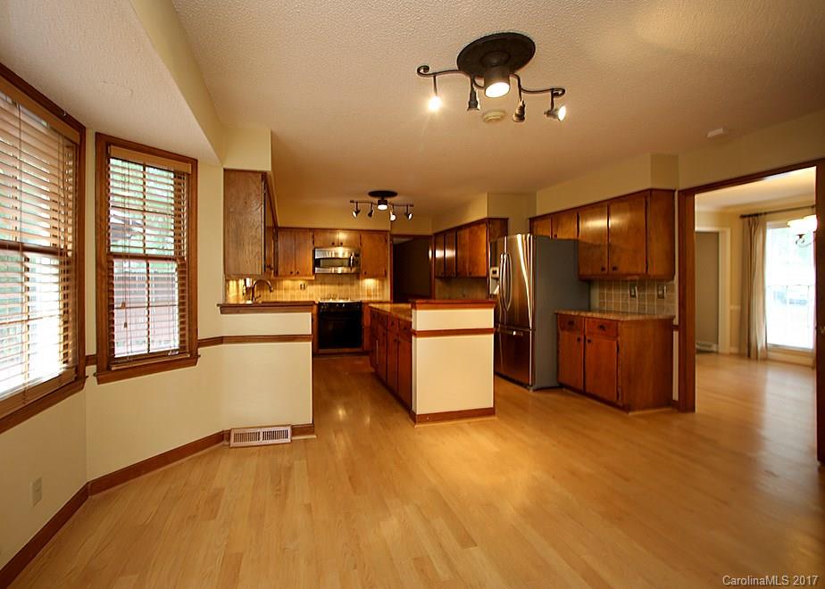 124 Friendfield Drive, Unit 10 Fort Mill, SC 29715 - Photo 9 of 24 a view of a kitchen with kitchen island stainless steel appliances wooden floor and a large window