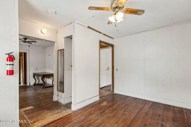 a view of a livingroom with wooden floor and a ceiling fan