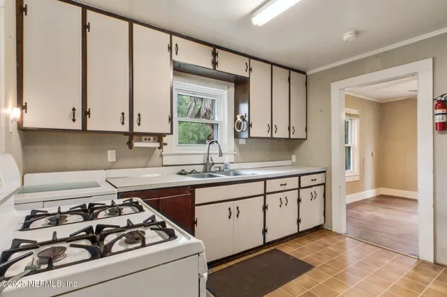 a kitchen with stainless steel appliances granite countertop white cabinets and a stove top oven