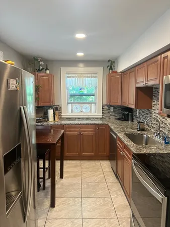 a kitchen with a sink a counter top space cabinets and stainless steel appliances