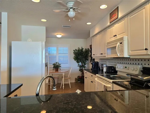 a room with furniture a large window and potted plants