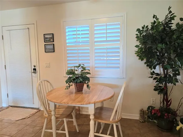 a dining room with furniture and potted plants