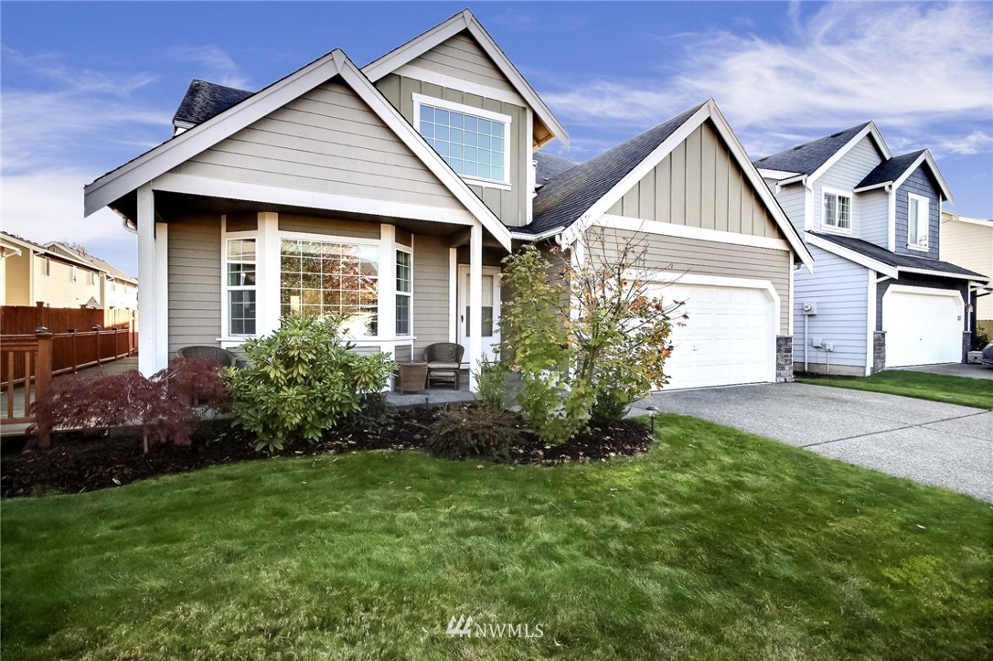 5217 Northeast 11th Street Renton, WA 98059 - Photo 1 of 25 a view of a yard in front of a house with plants and large tree