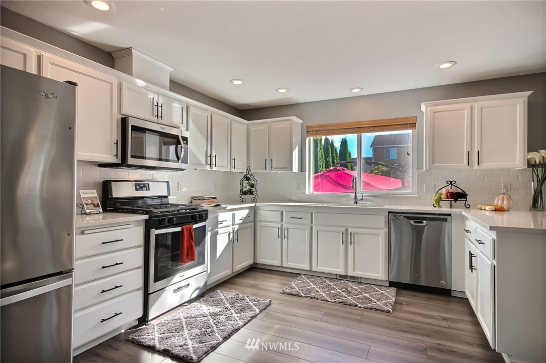 5217 Northeast 11th Street Renton, WA 98059 - Photo 4 of 25 a kitchen with granite countertop appliances cabinets and a sink