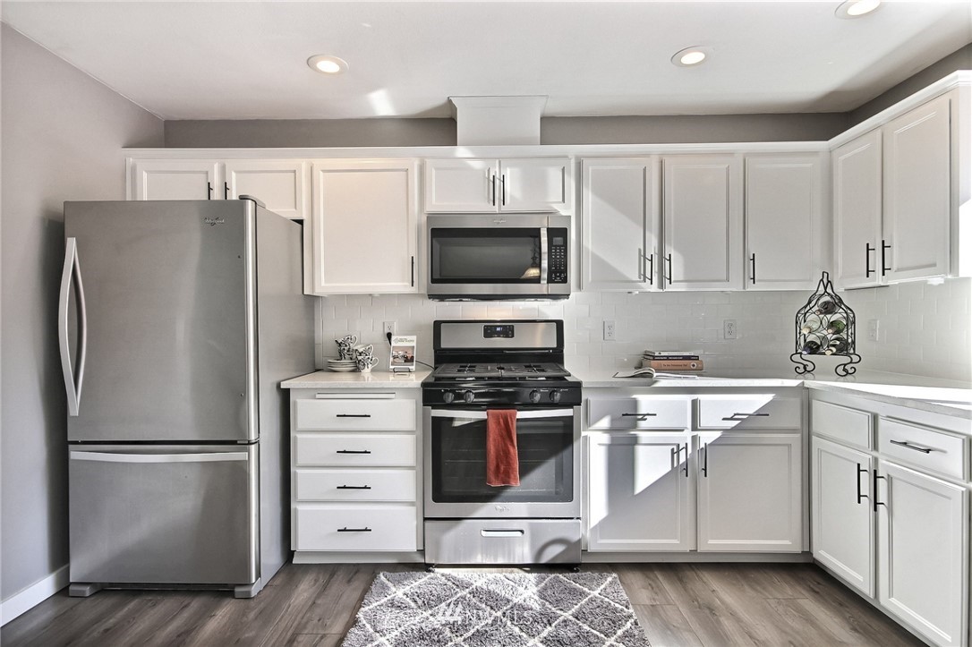 5217 Northeast 11th Street Renton, WA 98059 - Photo 6 of 25 a kitchen with stainless steel appliances white cabinets and a stove top oven