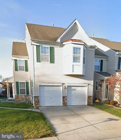 a front view of a house with a garden and yard
