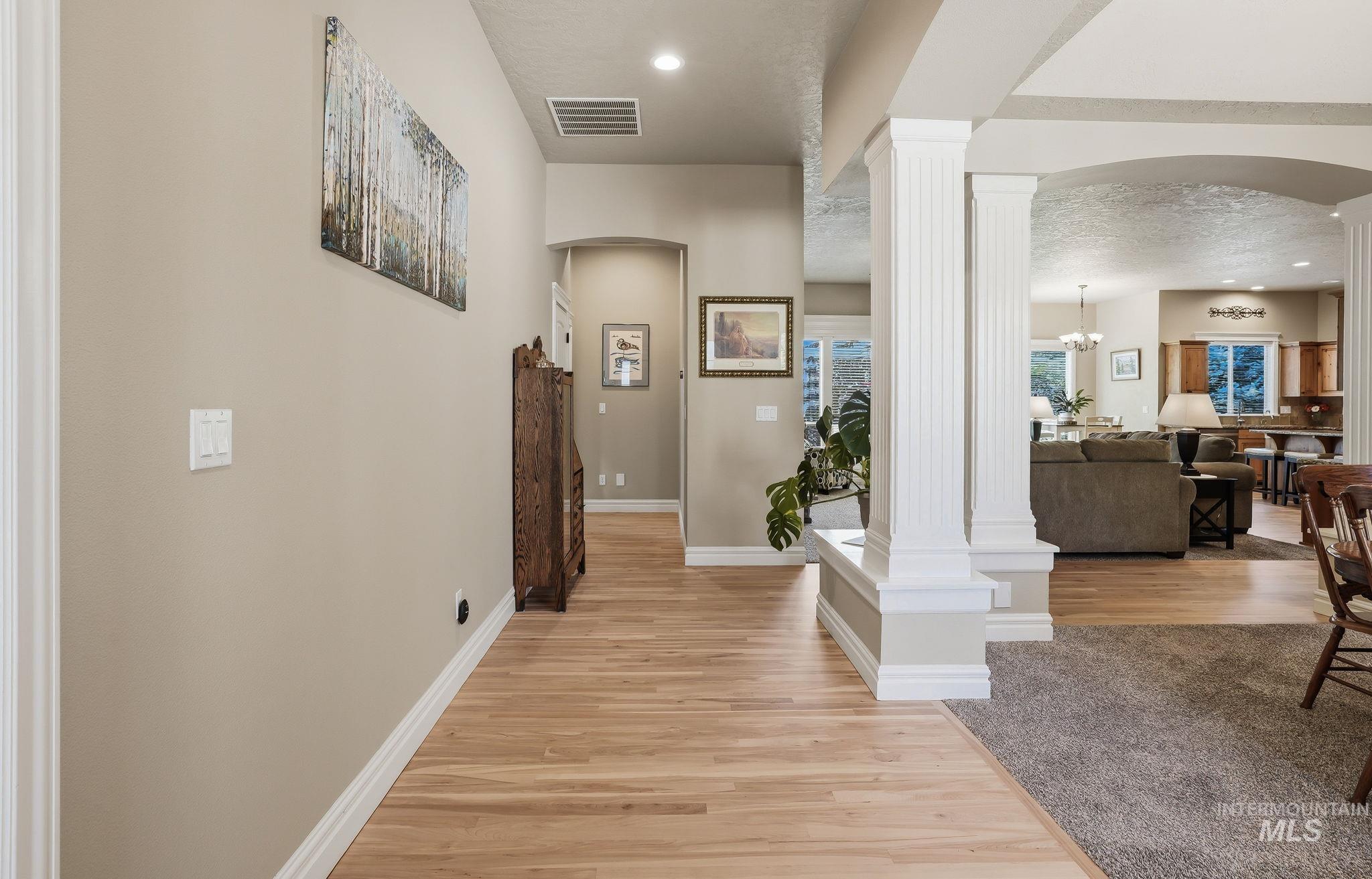 3969 North Hollymount Way Meridian, ID 83646 - Photo 5 of 47 Hallway featuring wood-finish flooring, neutral wall tones, and white trim