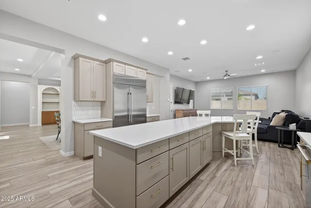 a large white kitchen with a large counter top space and stainless steel appliances