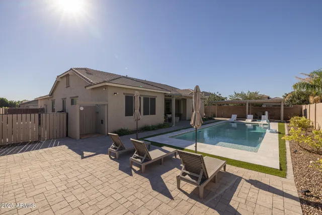 a view of a house with pool and sitting area