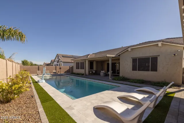 a view of a house with swimming pool and sitting area