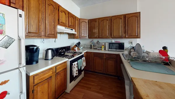 a kitchen with stainless steel appliances granite countertop a sink stove refrigerator and cabinets