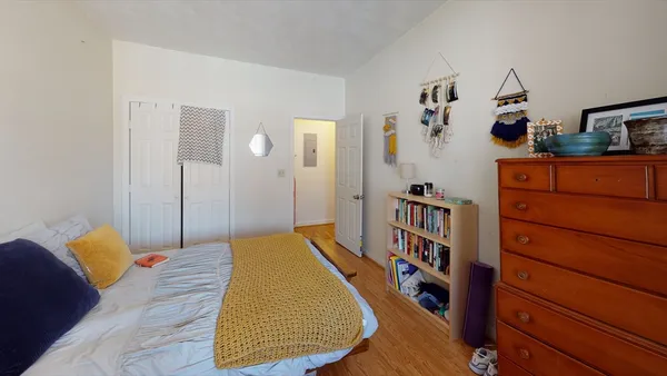 a bedroom with a bed and wooden floor
